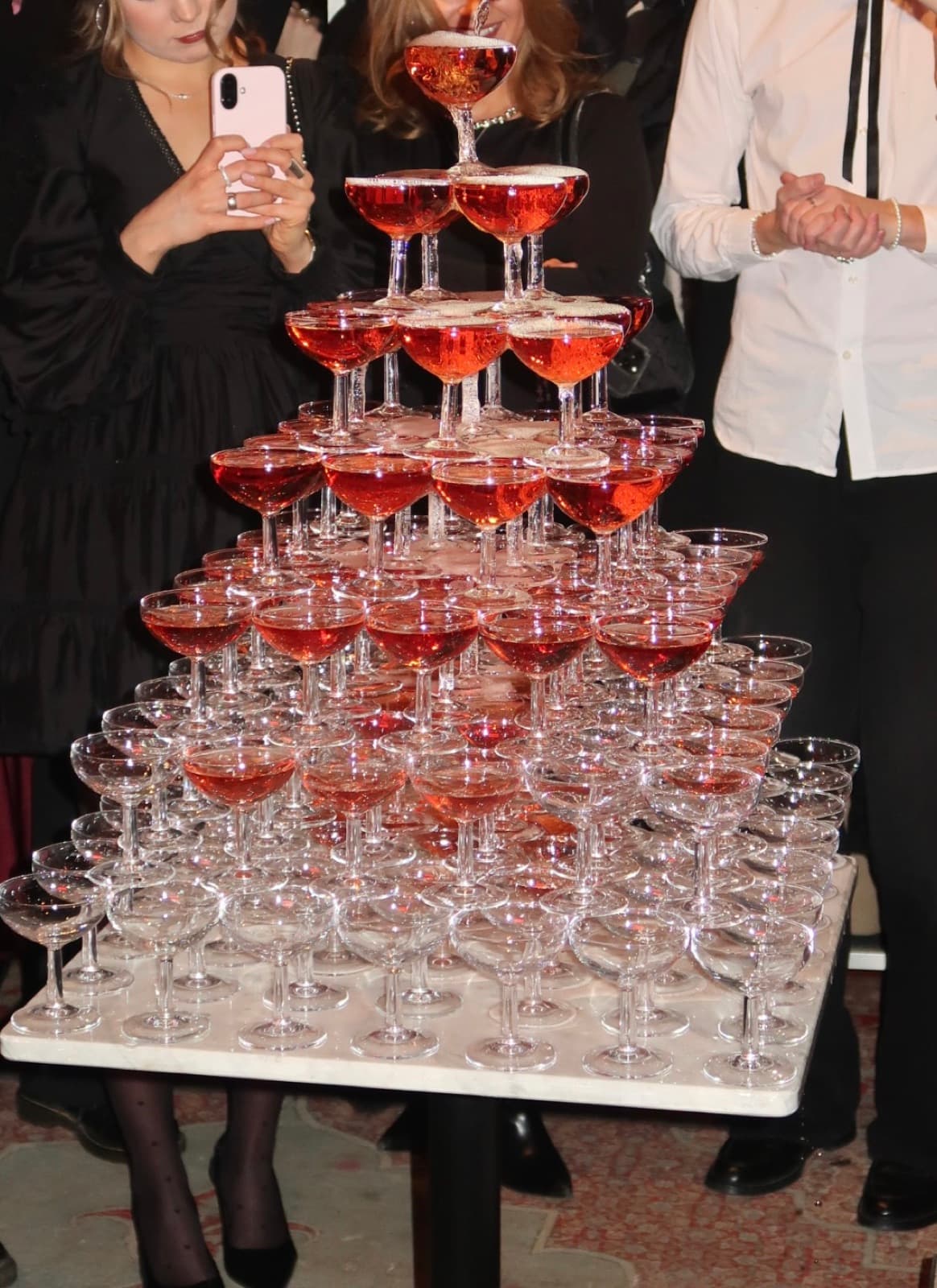 A champagne tower surrounded by guests at an Edna Social Club event in Helsinki