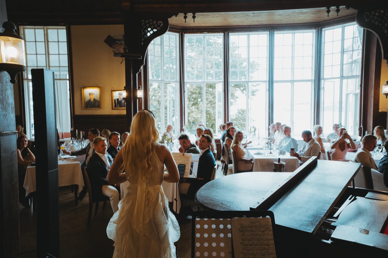 A singer performing beside a grand piano for guests at an Edna Social Club garden party in Helsinki
